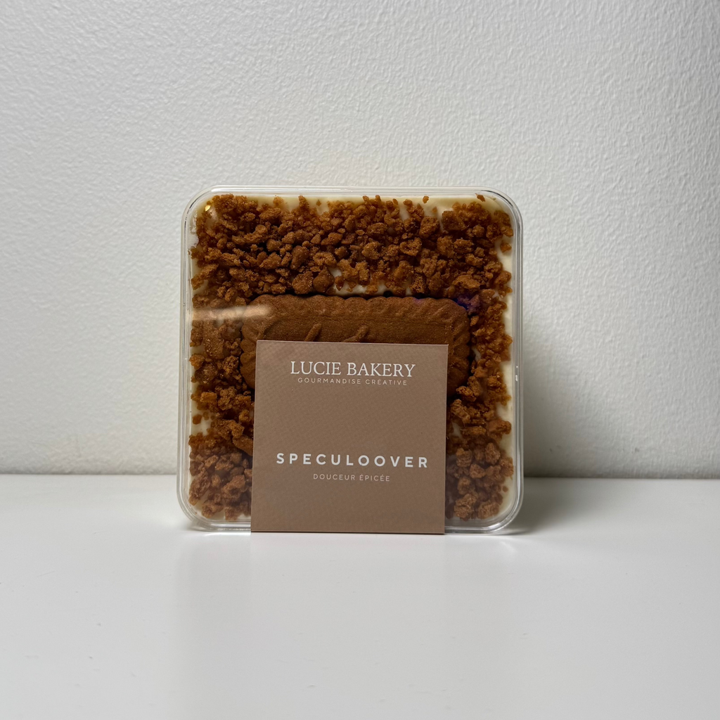 Tiramisu artisanal Lucie Bakery présenté dans un pot en verre, avec une crème onctueuse et des couches généreuses, posé sur une table en bois clair dans un décor chaleureux.